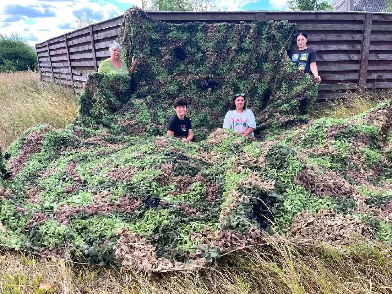 Volunteers of the “Library Spiders” group with a finished camouflage net. Photo: Bucha City Council