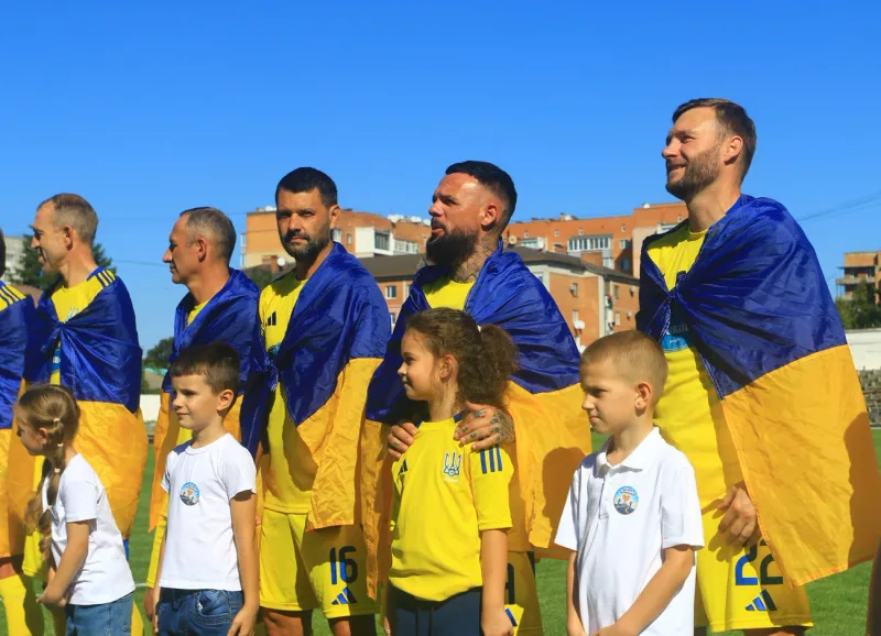 Veterans’ team players with children before kick-off