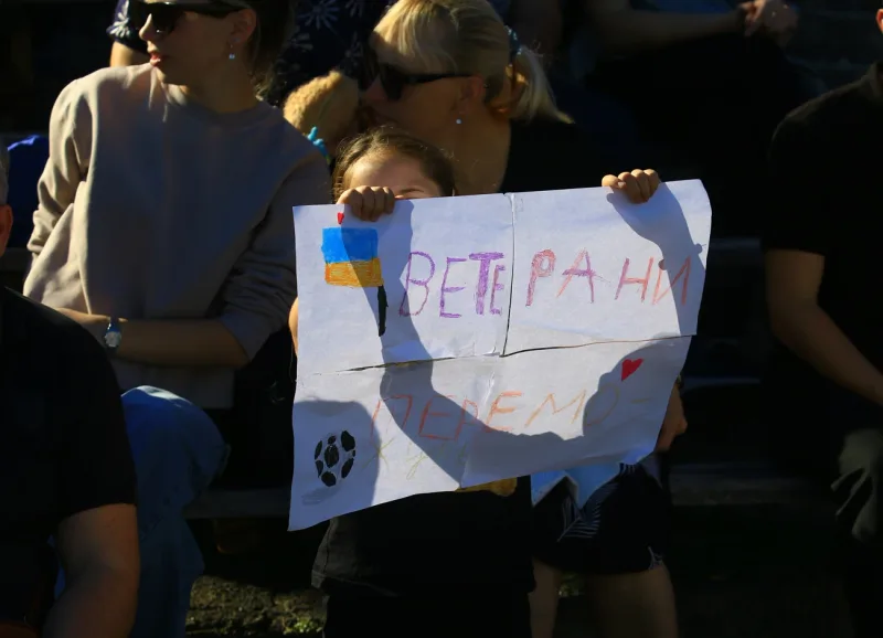Spectators with a home-made banner supporting the veterans