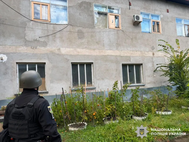 Поліцейський оглядає будинок із вибитими вікнами