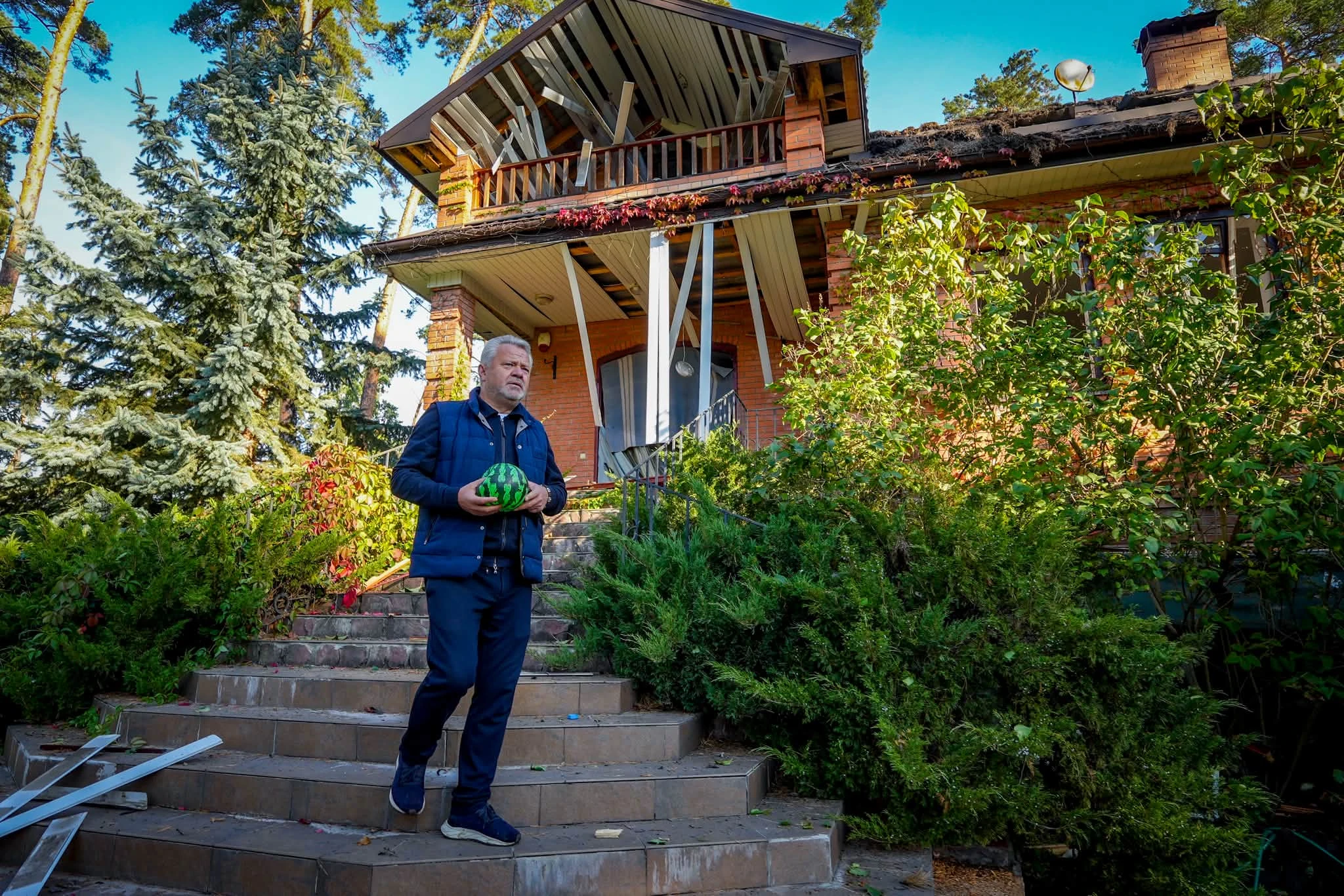 Anatolii Fedoruk outside a damaged house