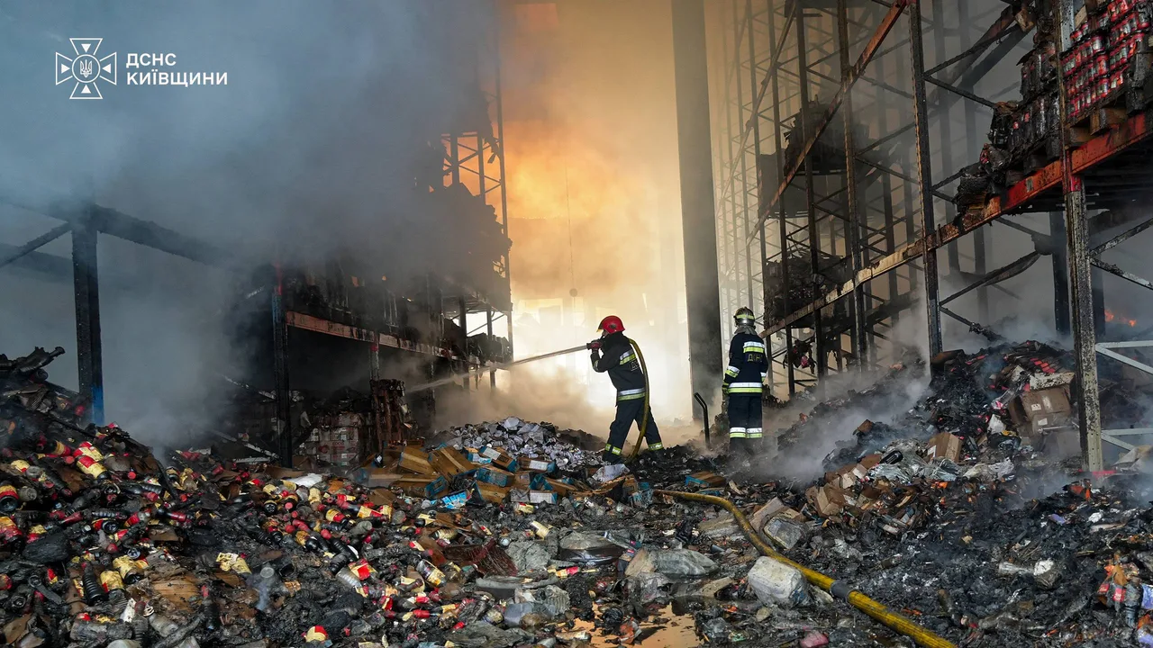 Rescuers fighting the fire inside the damaged logistics facility