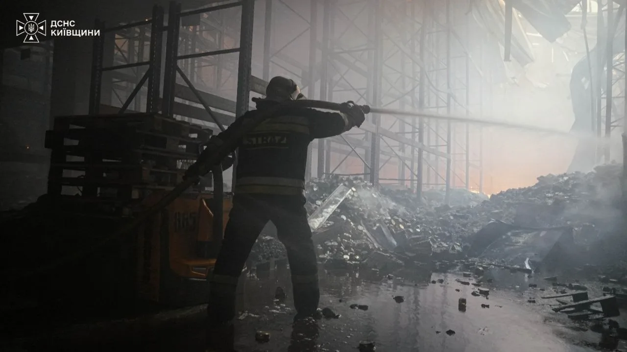 Rescuers deal with the aftermath of the attack on a warehouse in Bucha district