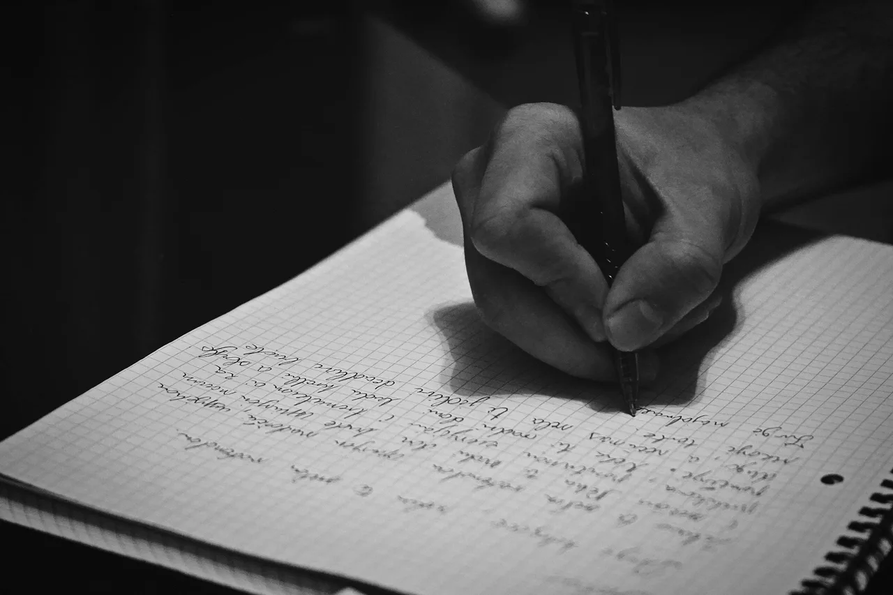 A person writing in a notebook. Illustrative photo