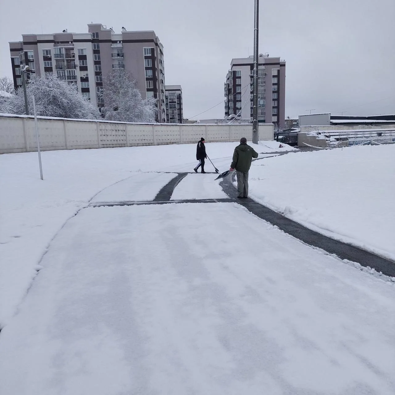 Stadium staff clearing snow