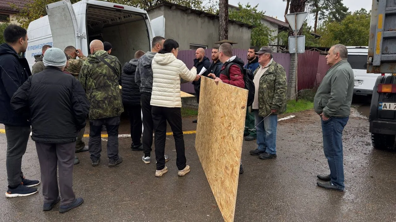 Біля гуманітарного штабу передають плиту OSB, щоб закрити вибиті вікна, Ірпінь, 19 жовтня 2026 року