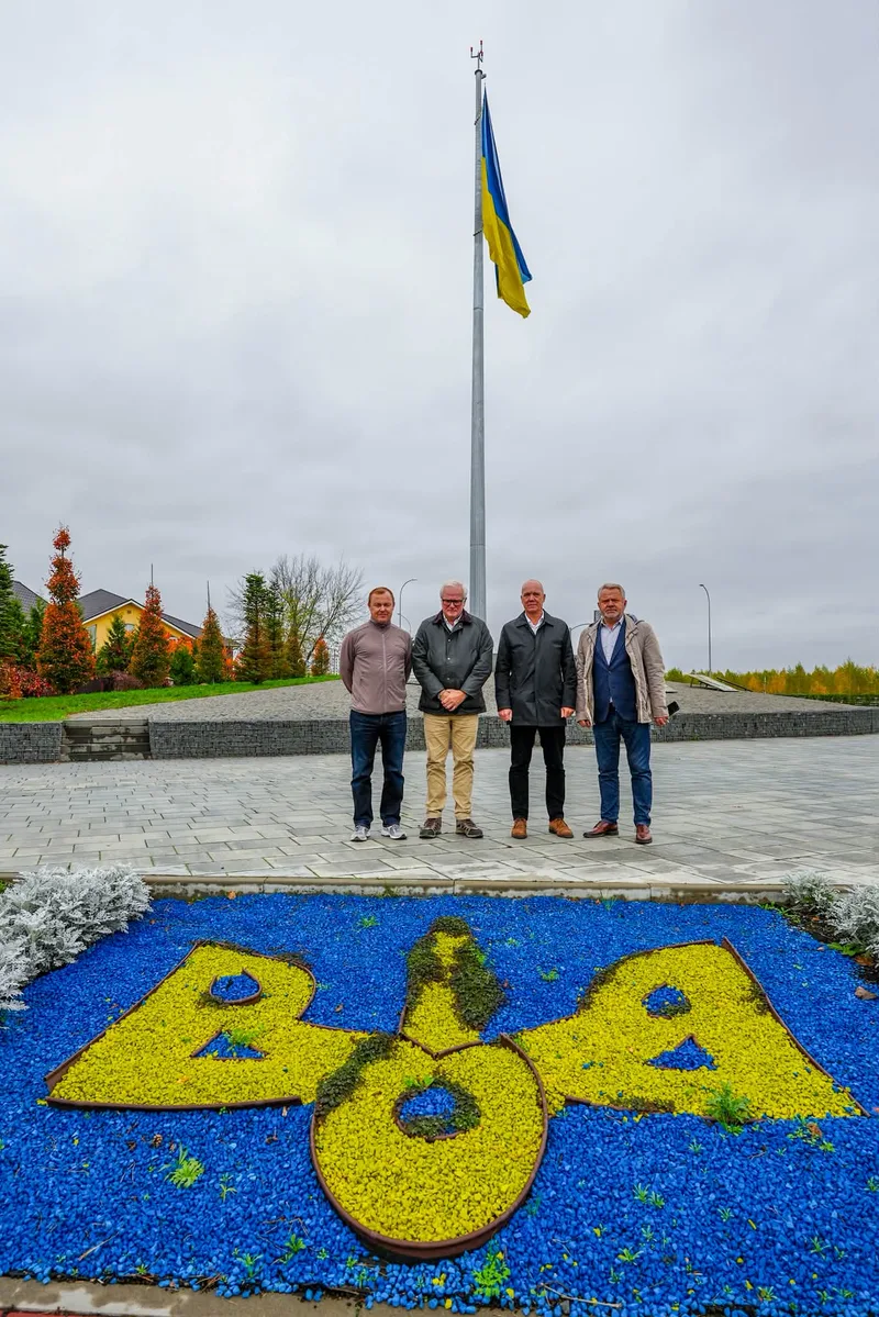 Відкрити фото на весь екран Делегація з Данії біля державного прапора в Бучі