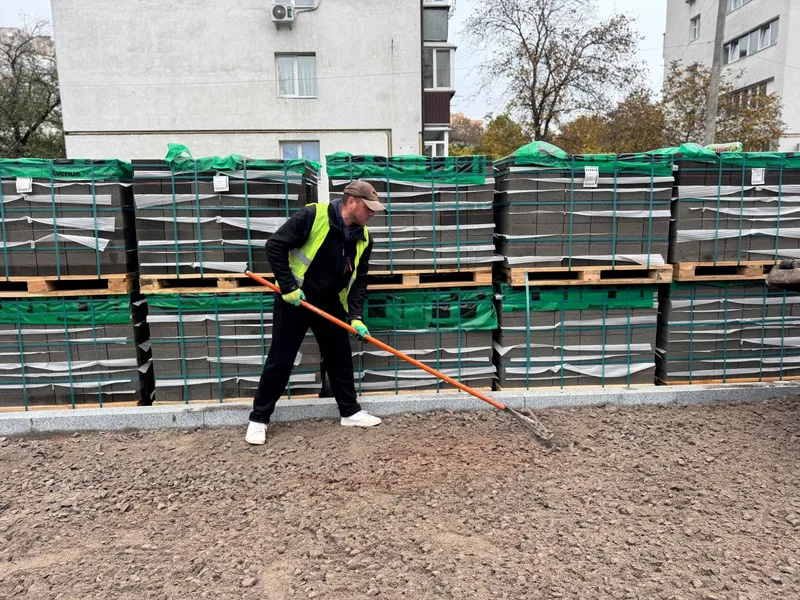 Відкрити фото на весь екран Вирівнювання щебеневої основи біля палет із плиткою